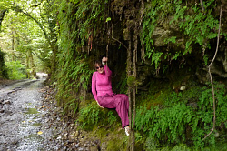 Эта девушка под скалой у лесной дороги туристка тура Знаменитая Тридцатка - легендарный маршрут 30. Эта дорога находится в зоне влажных субтропиков в районе города Сочи.